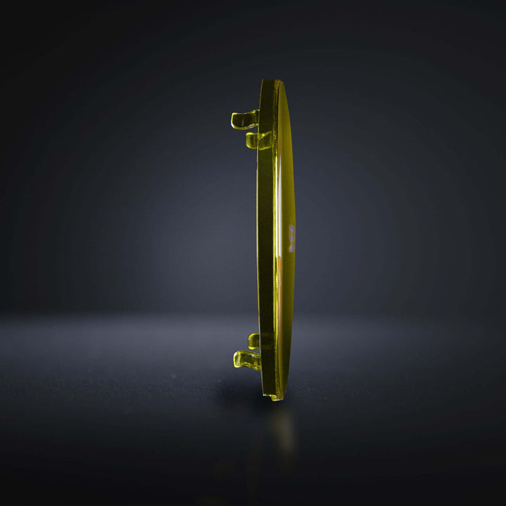 Side view of a yellow polycarbonate lens cover showing thickness and clips