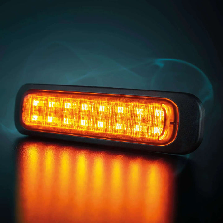 Ultra slim LED side marker with amber light and black frame on dark background